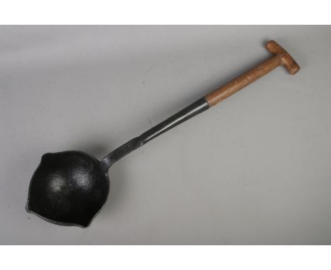 A vintage smelting ladle with cast iron bowl and wooden handle. Stamped WD on wooden section and stamped indistinct possible 