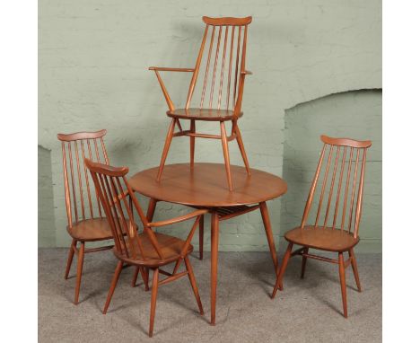 An Ercol circular dining table and four goldsmiths chairs. Includes two carvers. (73cm x 90cm x 100cm)  