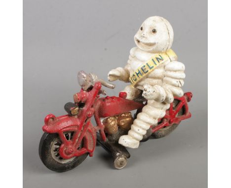 A cast iron model of the Michelin Man riding a motorcycle.  