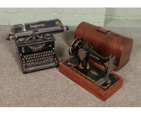 An early 20th century Imperial typewriter along with a cased hand crank Singer sewing machine.  No key for sewing machine.