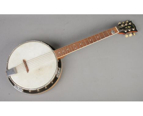 An Aria six string guitar banjo, with plectrum.  