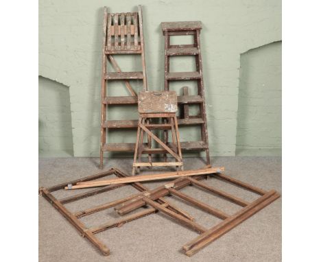 Three sets of wooden step ladders along with two clothes horses.  