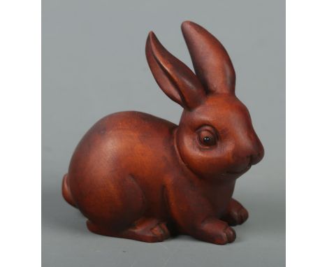 A hand carved hardwood netsuke of a rabbit  