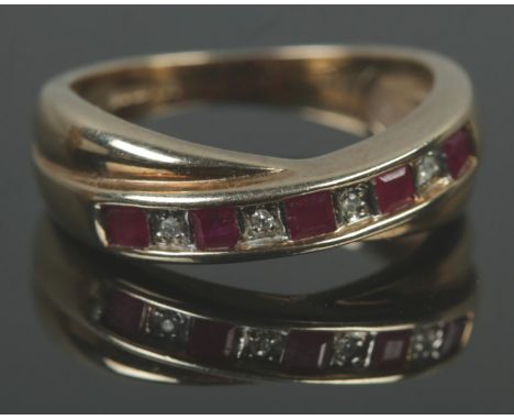 A 9ct gold ruby and diamond crossover ring. Size M, 2.93g.  