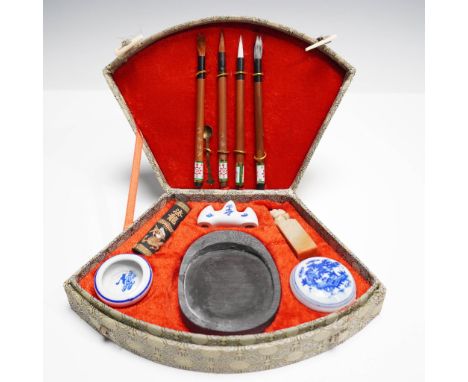 Complete traditional calligraphy set housed in a fan-shaped brocade case with floral medallion pattern and toggle closures. T