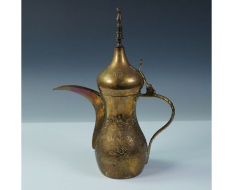 A traditional Middle Eastern dallah (coffee pot) crafted in brass, featuring a long curved spout, ornate finial, and hinged l