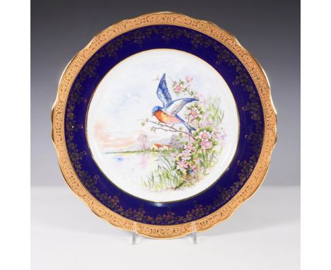 An exquisite Imperial Limoges porcelain plate featuring a beautifully hand-painted scene of a bluebird perched on a flowering
