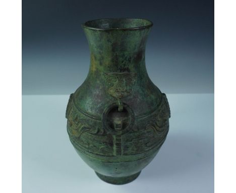 Archaistic bronze hu-form vessel featuring raised relief motifs of stylized birds encircling the midsection, echoing early Ch