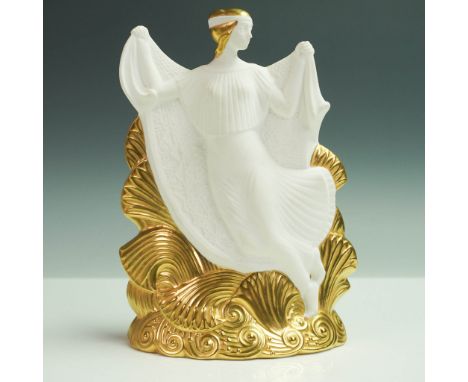 Crafted in white bone china, the figure features gilt accents applied to the hair, waves, and lower base. The sculpture depic