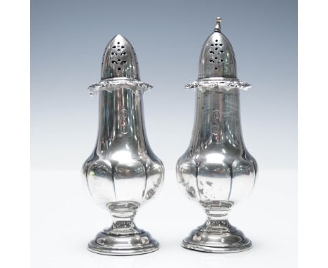 A pair of sterling silver salt and pepper shakers by Wallace Silversmiths in the Baroque Grande pattern. Featuring an elegant