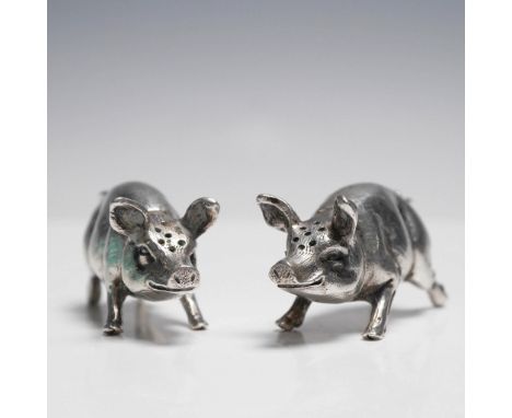 Charming and rare pair of figural salt and pepper shakers crafted in 800 silver, each modeled as a standing pig with delightf