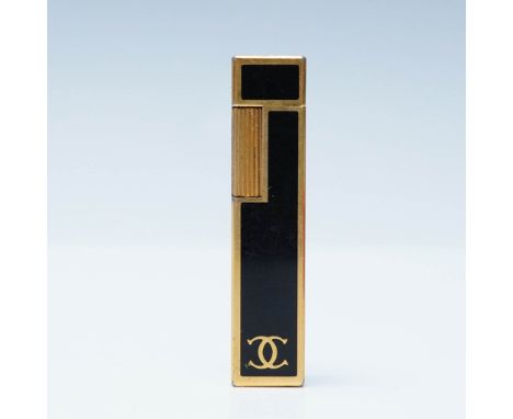A vintage Cartier butane lighter in a striking black and gold design, housed in its original red Cartier box. The sleek recta