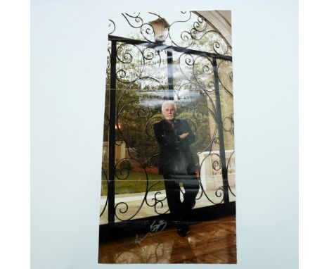 Color poster featuring a full-body image of country music legend Kenny Rogers leaning casually against ornate wrought iron ga