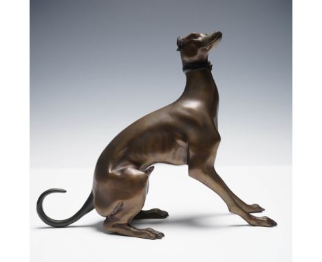 A finely cast bronze sculpture of a seated greyhound or whippet, rendered with a sleek and elegant form. The figure captures 