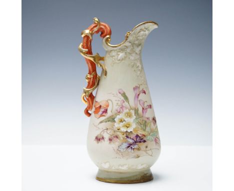 This late 19th to early 20th century piece features an ornate organic form with high-relief leaf decoration near the spout, a