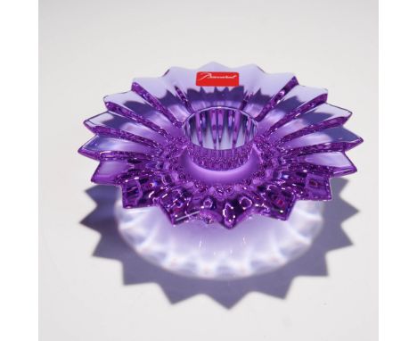 Crafted in purple-colored crystal. The form features a radiating, fluted design with a starburst motif and a tapered center o