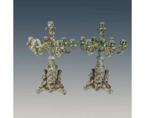 Exquisite pair of hand-painted porcelain candelabras, each featuring six candle holders adorned with applied floral garlands 