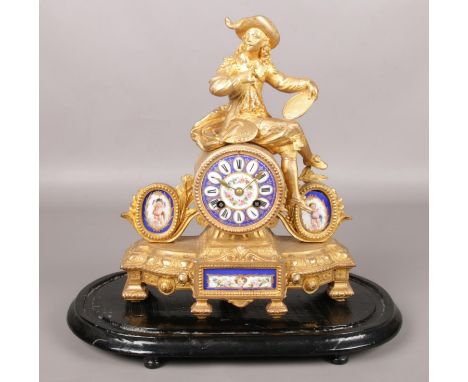 A French gilt metal mantel clock surmounted with an artist painting a portrait and having Sevres style painted porcelain dial