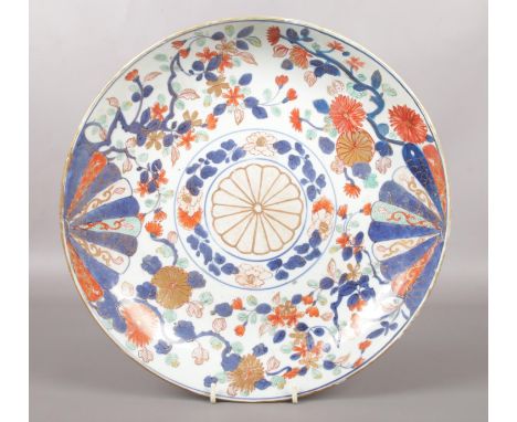 A 19th century Chinese Imari dish. Painted with a brocade pattern incorporating mons and trailing foliage. Underglaze blue co