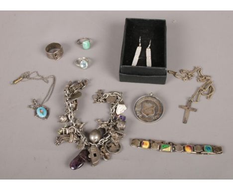 A quantity of mostly silver jewellery. Including charm bracelet some silver charms, silver medal, silver ring formed as a bel