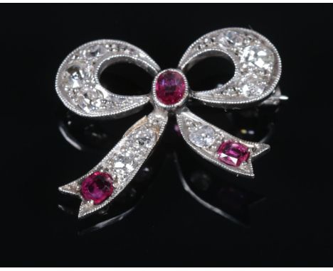 An Art Deco ruby and diamond brooch in the form of a bow. 2cm x 2.2cm. 3.37g.  Jewellers repair to one tail of bow.