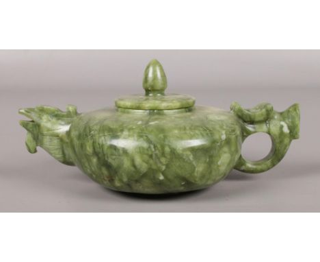 A Chinese jade teapot. The spout formed as a birds head and the handle as a dragons head. Length 17cm.  