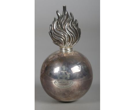 An Edwardian silver military grenade table lighter bearing the Brinkley family coat of arms to one side and a rearing dragon 