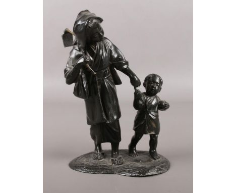 A Japanese spelter figure group of a mother and child. Marks to base. 22cm.  