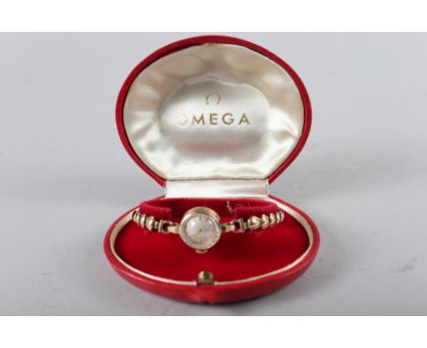 A lady's Omega 9ct gold cased wristwatch with silvered dial and baton numerals, on 9ct gold bracelet, in red morocco leather 