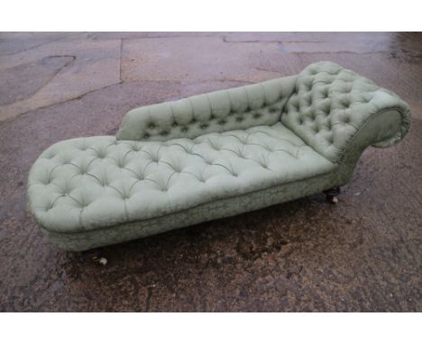 A chaise longue, button upholstered in a green brocade, on turned supports, 72" wide 