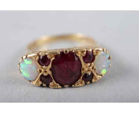 An 18ct gold dress ring set central ruby and two opals 