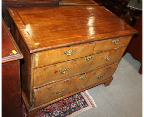 An 18th century walnut and banded chest of two short and two long drawers with brass handles and pierced escutcheons, on brac
