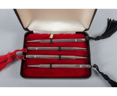 A set of four sterling silver bridge pencils with engine turned decoration, in fitted case 