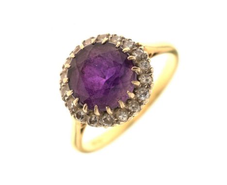 Amethyst and diamond cluster ring, the yellow metal shank stamped '18ct', the circular facteted amethyst within a border of b