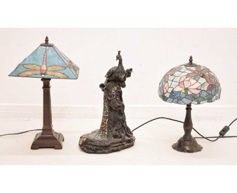 Tiffany-style resin figural peacock lamp, 49cm high, together with two table lamps, each leaded lamp shade decorated with dra