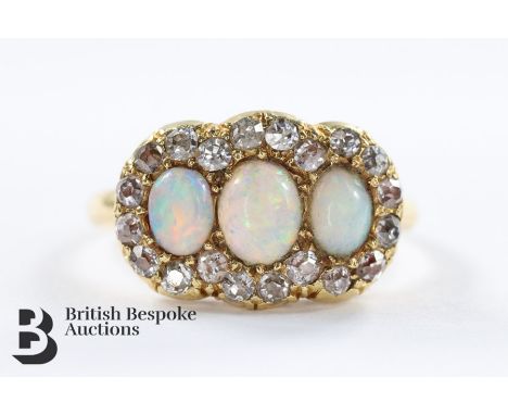 19th Century 18ct yellow gold diamond and opal ring. The ring set with one opal measuring 5 x 4 mm and two 4 x 3 mm, surround