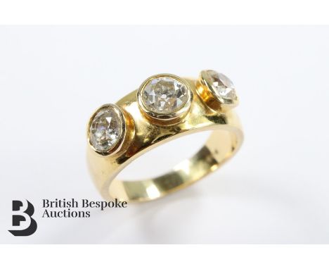 A bespoke 14/15ct (tested) yellow gold three stone diamond ring, size. The ring having a central diamond approx 60 pts flanke