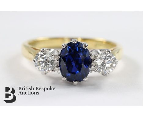 18ct yellow and white gold royal blue and sapphire diamond ring. The oval sapphire measures 6 x 4.7mm flanked by two diamonds