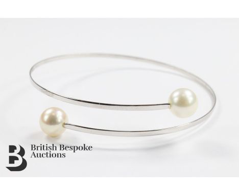 18ct white gold and pearl torque bracelet. The bangle set with two Akoya cultured pearls of 7.5 mm each, approx 3.2 gms, toge