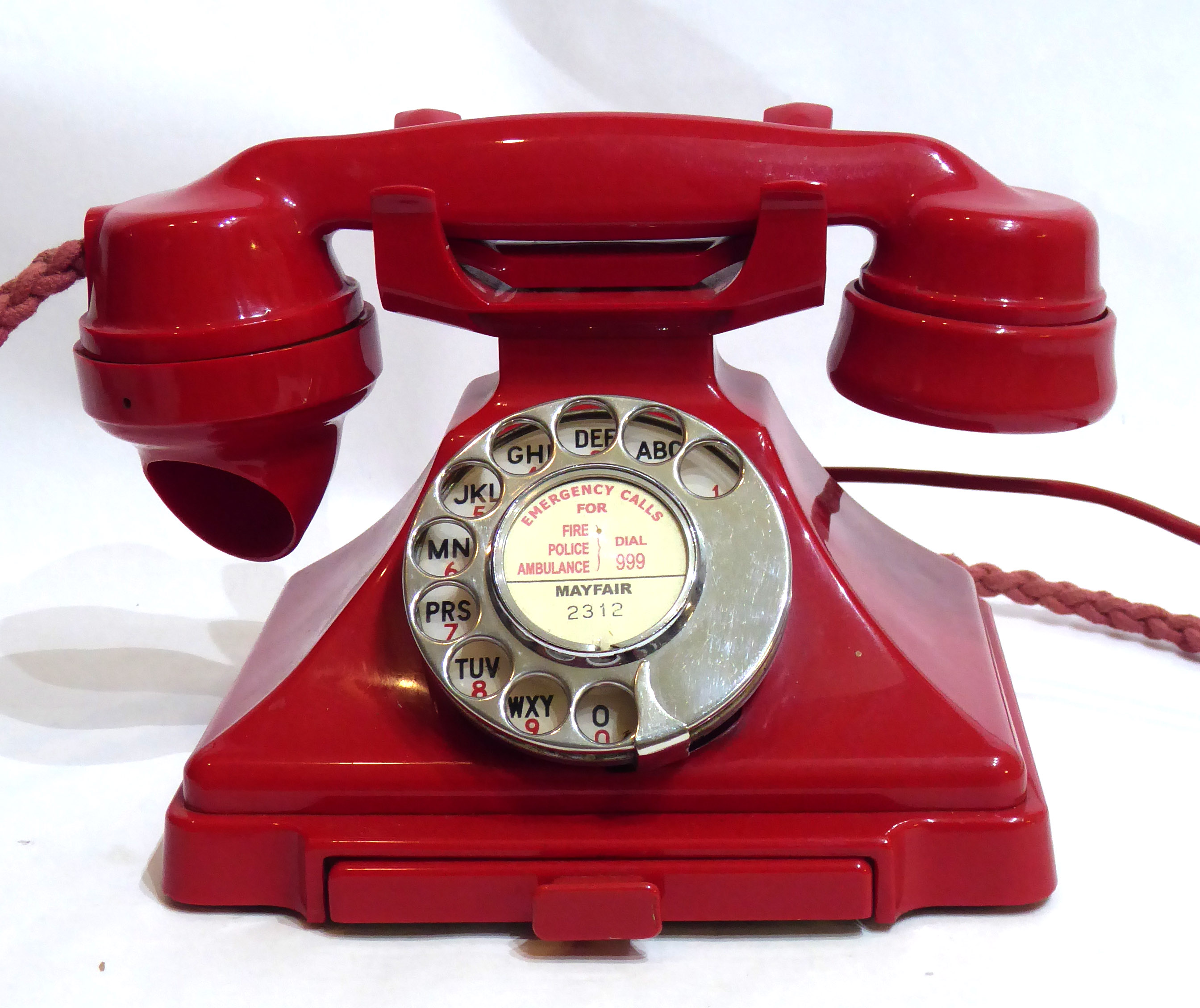 A VINTAGE RED BAKELITE TELEPHONEWith chrome dial.