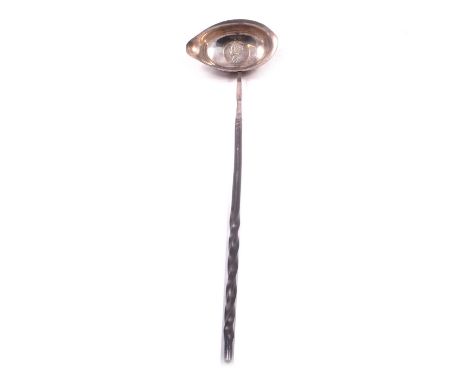 A Georgian white metal punch ladle, unmarked, inset with a George II shilling (1758), twisted whalebone handle, 34.5cm.