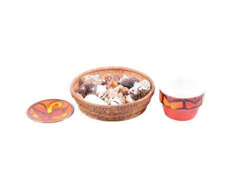A collection of cowrie shells from Mombasa, various sizes, in a wicker bowl; Claude C Woltz Jr &amp; David B Belcher, Collect
