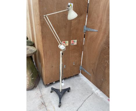 A VINTAGE ANGLE POISE LAMP ON A CAST IRON TRIPOD BASE WITH CASTERS 