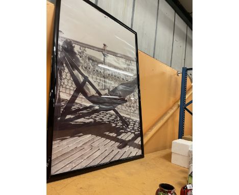 A VERY LARGE KODAK BLACK AND WHITE FRAMED 1940'S/1950'S PRINT OF A LADY SUNNING HERSELF ON THE PIER 156CM X 106CM 