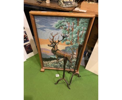 A FIRE SCREEN WITH A TAPESTRY OF A STAG AND TWO RUSTIC IRON CANDLE HOLDERS 