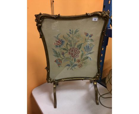 AN ORNATELY FRAMED CROSS STITCHED FIRE SCREEN WITH A FLOWER DESIGN 