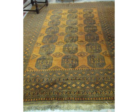 Large Middle Eastern design carpet on an orange ground with geometric banding and gul central decoration.(B.P. 24% incl. VAT)