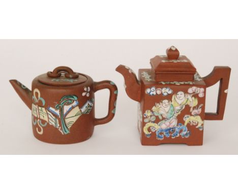 Two Chinese Yixing teapots, the first of square form enamel decorated with two figures in a garden, the second of cylindrical