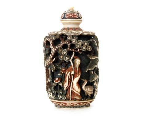 A 19th Century Chinese part stained ivory snuff bottle carved in deep relief with figures between prunus trees with scroll wo