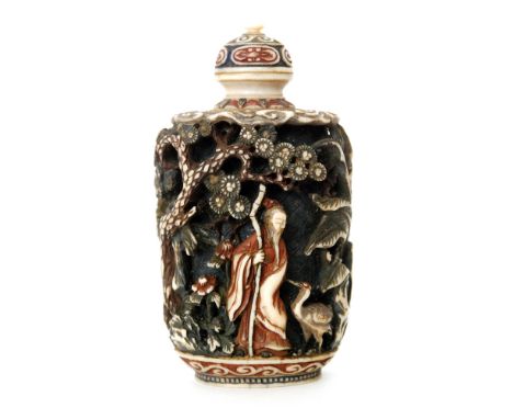 A 19th Century Chinese part stained ivory snuff bottle carved in deep relief with figures between prunus trees with scroll wo